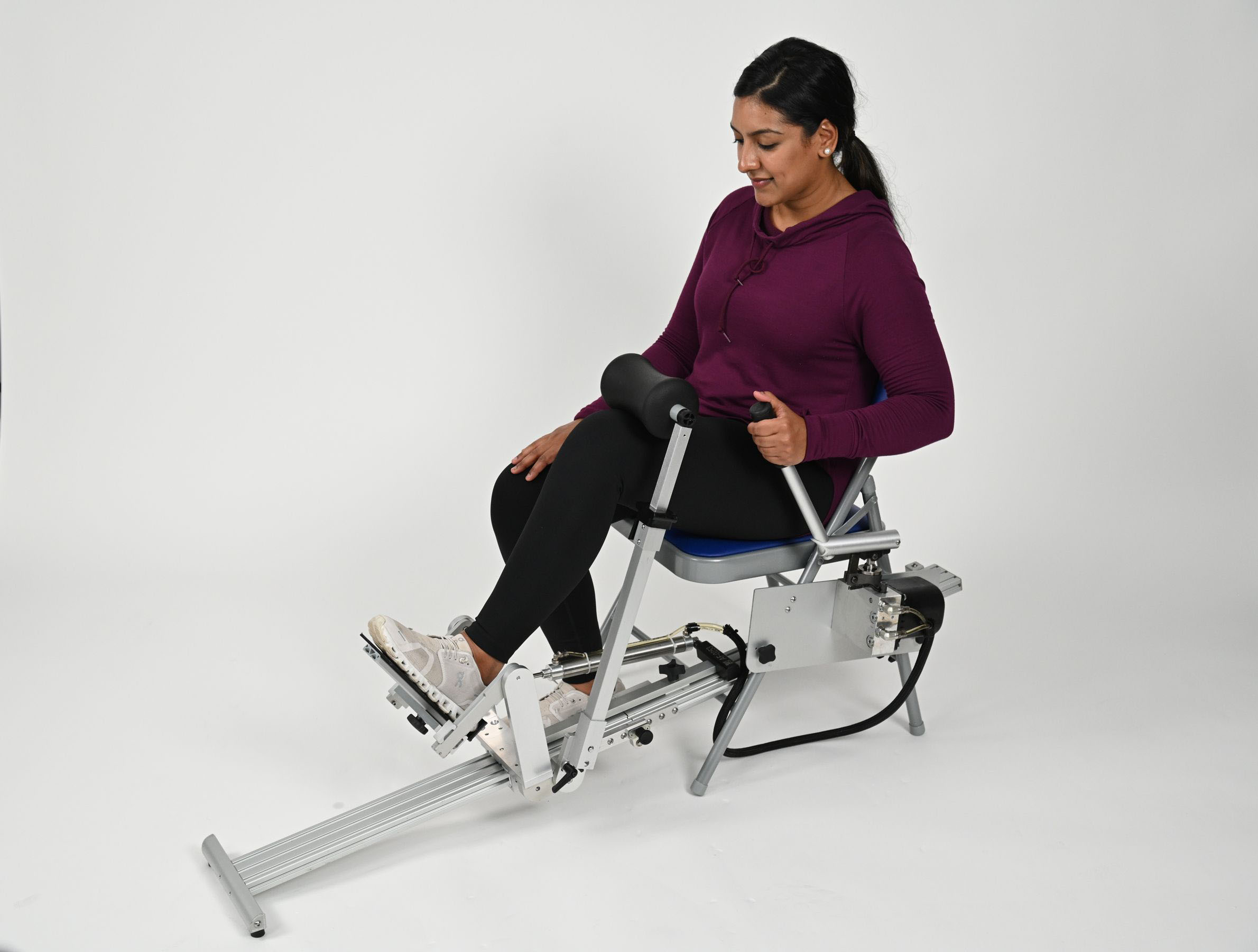 Person sitting in an ERMI Ankle Flexionater device, performing high-intensity stretching to restore ankle mobility at home